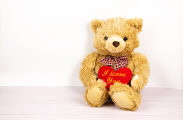 Teddy bear with a heart on a light background. Children's toy, children's room. Valentine's Day