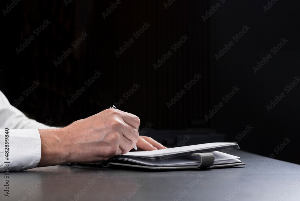 Poster business banner with hands writing in planner. blck background with copy space for text.