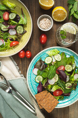 Bowl of salat,pumkin and sunflower seeds,olive oil,fork and knife.Tasty and healthy food concept. Flat lay. Rustic food photography..