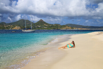 Young woman in bikini relaxing at the beach, White Island, Grenada.