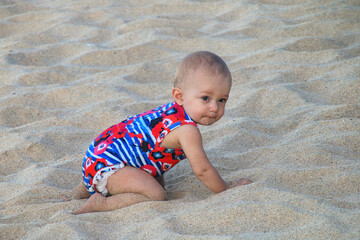 Baby crawling in a soft beach sand