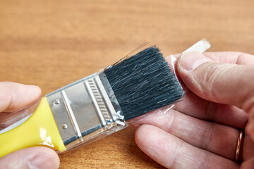 The man takes a brush from the factory packaging.