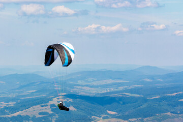 paragliding above the mountain valley. extreme outdoor sports. adventure and travel concept. clouds...
