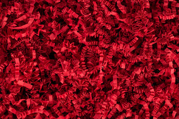 Glamor view from above red decorative paper, filler for gifts, chips. Cut out wrapping paper.