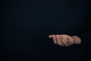 Open woman's hand, palm up isolated on black background. Mock up. Copy space. Template. Blank.