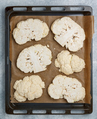 Cauliflower. Sliced raw steaks are ready for baking on a baking sheet. Healthy nutrition, diet. Vegan and vegetarian cuisine. Fresh Vegetables. Selective focus, top view