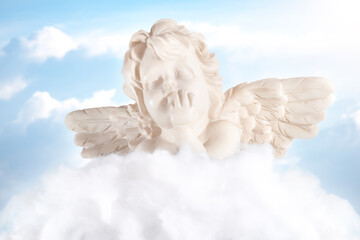 Little angel dreaming on the clouds. Sweet little angel with wings lying on a cloud with the sky in...