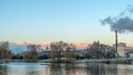 Smoking chimneys of a thermal power plant against a winter cloudy sky. Ecological problems concept. Space for text.