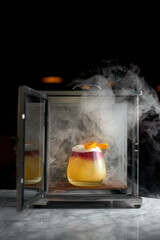 Negroni cocktail in a container with smoke steaming on a marble background