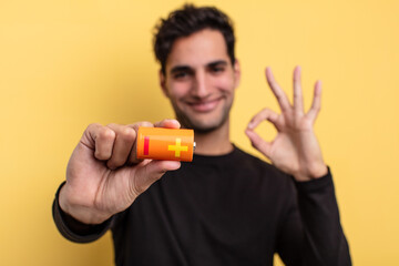 young handsome hispanic man with a battery