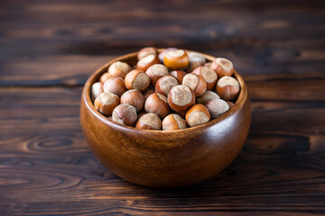 food, hazelnuts in a wooden bowl on a dark wooden background,selective focus