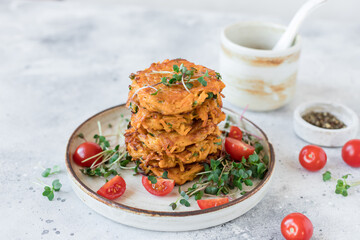 Crispy sweet potato fritters served with tomatoes and microgreens. Vegan food concept. copy space....