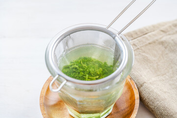 茶こしでグラスに入れる緑茶