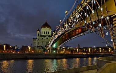 Fototapeta na wymiar Moscow. Russia. October 01, 2021. Evening view of the bridge over the Moskva River decorated with New Year's illumination to the Orthodox Cathedral of Christ the Savior.