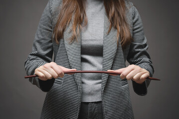 Angry teacher is bending a school pointer stick close up.