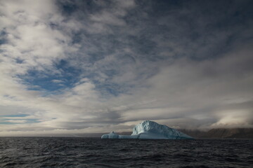 duże góry lodowe o różnych kształtach na morzu w pochmurny dzień - 482907808