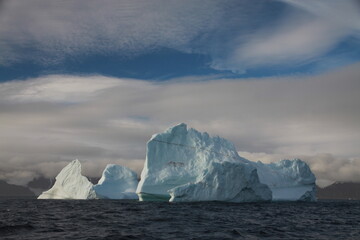 duże góry lodowe o różnych kształtach na morzu w pochmurny dzień - 482907822