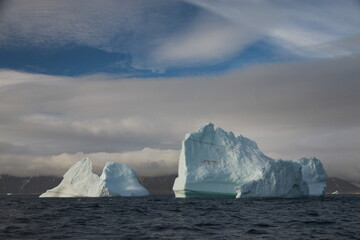duże góry lodowe o różnych kształtach na morzu w pochmurny dzień - 482907830