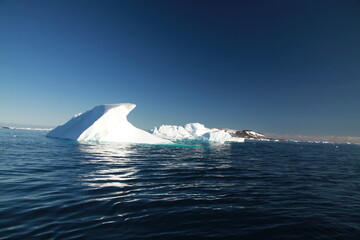 różnokształtne duże  góry lodowe na morzu w słoneczny dzień