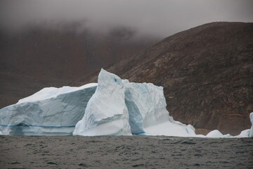 majestatyczna góra lodowa u wybrzeży grenlandii z naturalnie powstałym w niej odłamem w...