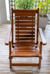 The reclining wooden chair on the terrace of the urban house.