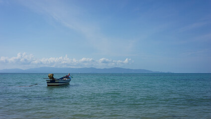 Landscape with a boat in the sea and blue sky with white clouds © Natalia