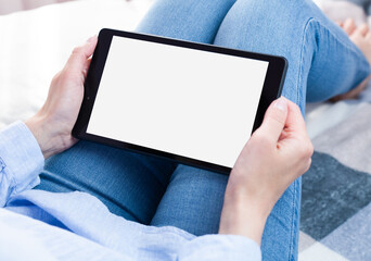 Woman's hands holds digital tablet tablet with white screen. Tablet blank screen mockup. Close-up. Copy space.