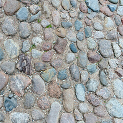 fragment of a stone path made of stones of different sizes and colors on the territory of the Pskov...