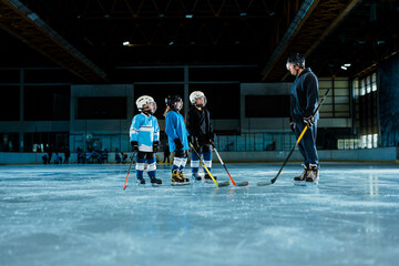 Children Hockey Team on Ice Rink with trainer - obrazy, fototapety, plakaty