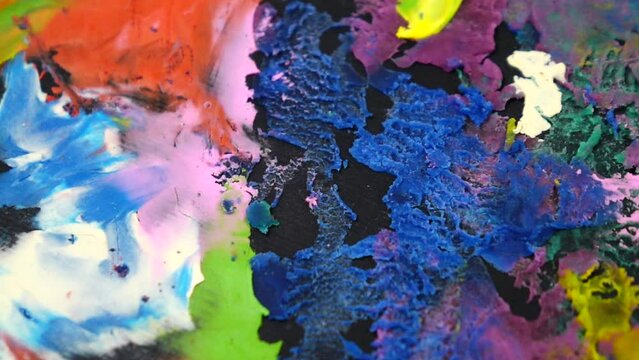 Cardboard with multi colored plasticine abstract painting rotate on a photography turntable, slow motion
