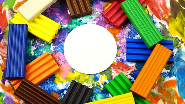 Multi colored rectangle pieces of plasticine, a cardboard with plasticine abstract painting rotate on a photography turntable