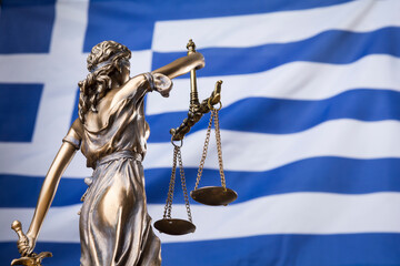 The statue of justice Themis or Justitia, the blindfolded goddess of justice against the national flag of Greece, as a legal concept