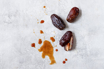 Date syrup and three dates on the background