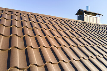 Closeup of house roof top covered with metallic shingles © bilanol