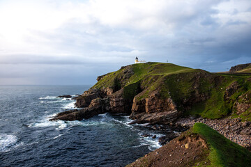 Fototapeta na wymiar Stoer Lighthouse, Unapool, Scotland - Dramatic stone cliffs in the foreground.