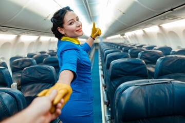 Female flight attendant in air hostess uniform holding hand and showing approval gesture while...