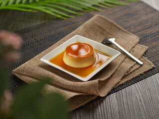 Pudding creme caramel custard in a white dish on wooden background