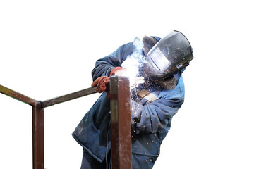 A worker in blue overalls and a protective mask connects metal elements by electric welding. Sparks...