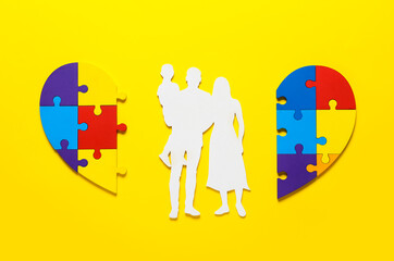 Colorful puzzle pieces and figure of family on color background. Concept of autistic disorder