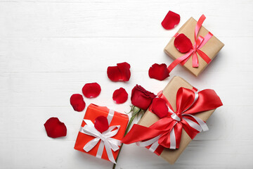 Gifts with rose petals on white wooden background. Valentine's Day celebration