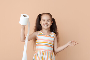 Funny little girl with ponytails holding roll of toilet paper on beige background
