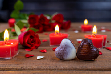 Obraz na płótnie Canvas Valentines Day concept chocolate candies and red roses with candles