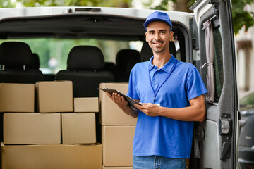 Male courier of delivery company near automobile with parcels