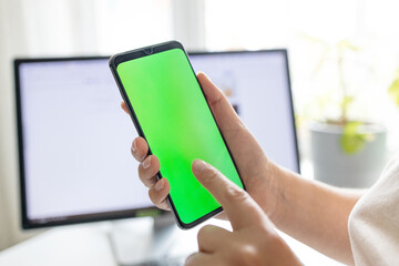Smartphone with vertical green screen in tram chroma key smartphone technology cell phone in woman hands. Hand with cellphone display