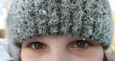 eyes of a girl in a winter snowy hat