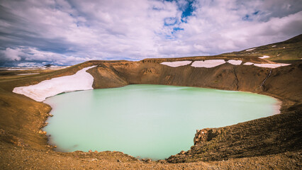 Weiße Schneefelder am Rand des türkisen Kratersees des Viti Kraters im Geothermalgebiet Myvatn , Island. © Hendrik