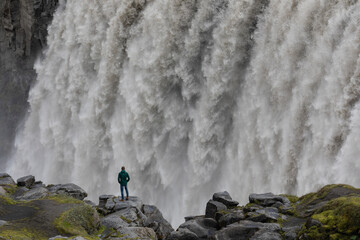 Ein Mensch schaut in die mächtigen Sturzfluten des Dettifoss.