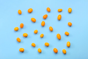 Tasty kumquat fruits on blue background