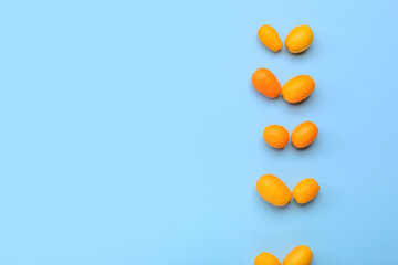 Tasty kumquat fruits on blue background