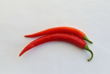 two red hot peppers on a white background